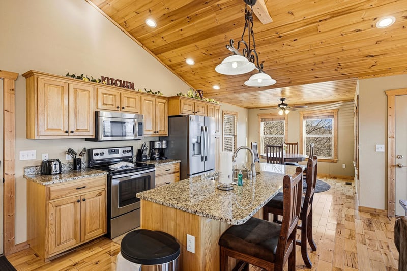 Your fullyequipped kitchen awaits with granite counters, stainless appliances, and rustic wood ceilings—perfect for cooking memorable meals together.