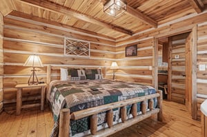 Rest peacefully in your rustic log cabin bedroom, where warm wood surrounds you and cozy quilts invite sweet dreams.