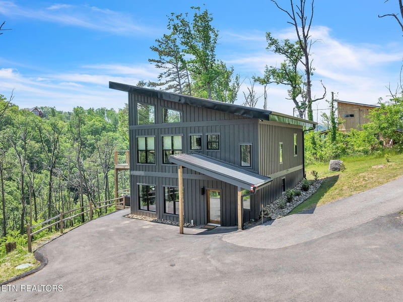 Modern mountainside retreat with sleek architectural lines and lush forest surroundings. The property offers a private wooded setting with convenient access and ample natural light.