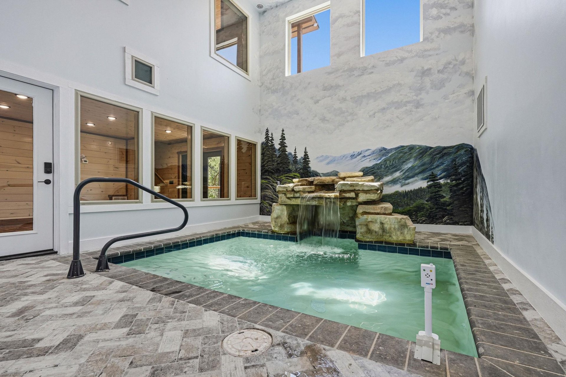 Step into your private oasis—an intimate courtyard pool with a cascading stone waterfall and open sky above. Warm up in the spalike setting surrounded by elegant tile and glimpses of the indoors thro