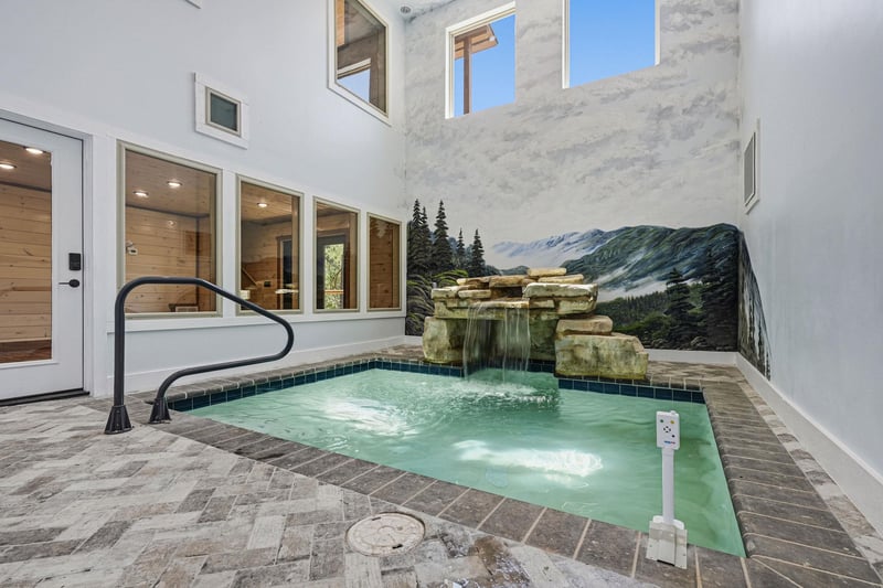 Step into your private oasis—an intimate courtyard pool with a cascading stone waterfall and open sky above. Warm up in the spalike setting surrounded by elegant tile and glimpses of the indoors thro