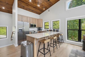 Step into your open kitchen bathed in natural light, where a spacious island invites you to gather over morning coffee or prepare meals together.