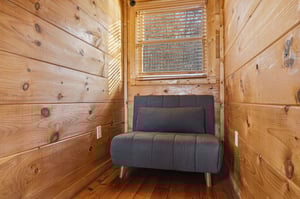 Curl up in your cozy reading nook with warm wood walls surrounding you and natural light streaming through the window blinds.