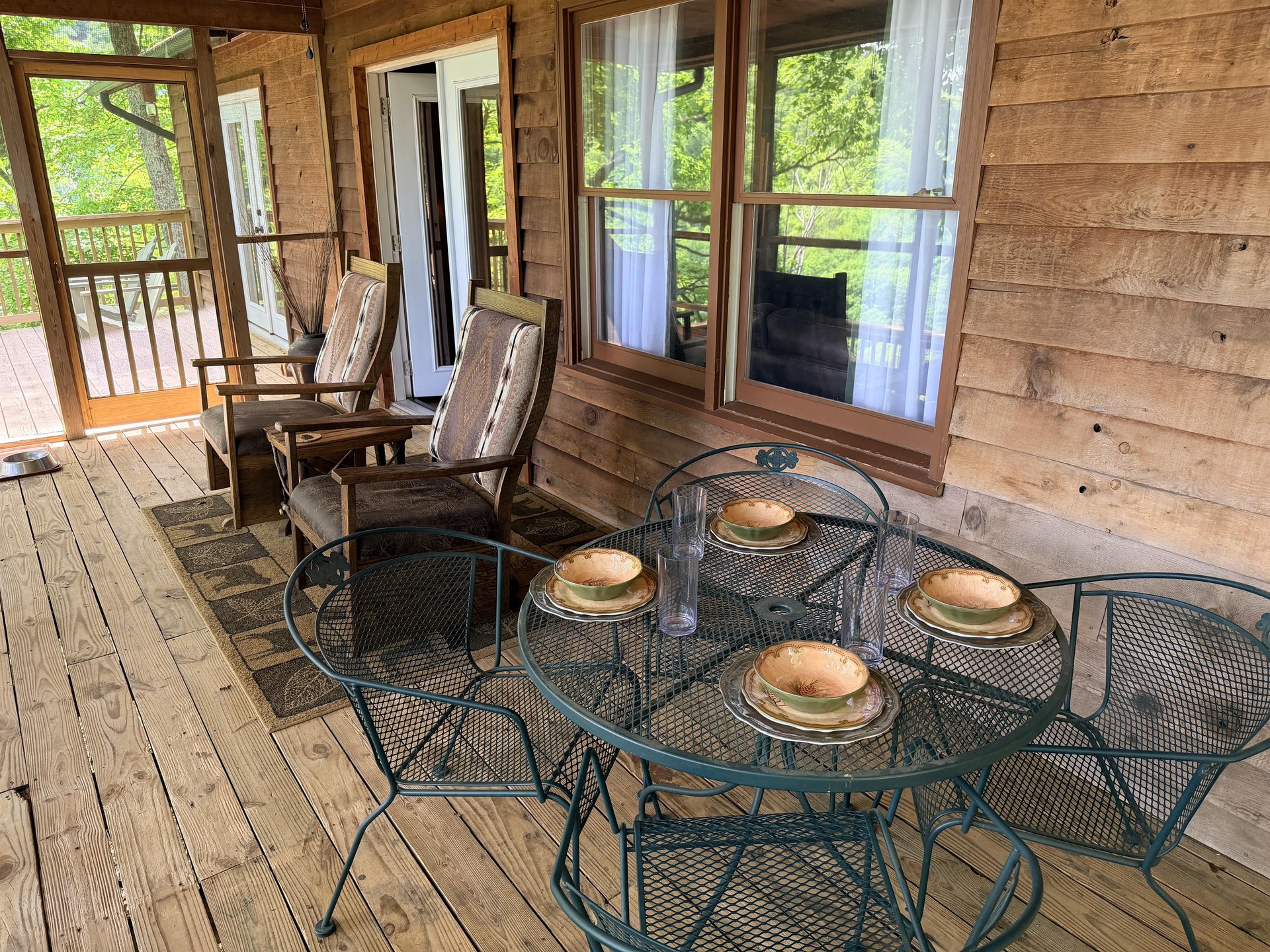 Your private screened porch invites peaceful mornings with fresh air, garden views, and space for four at the metal dining set—perfect for coffee or evening meals.
