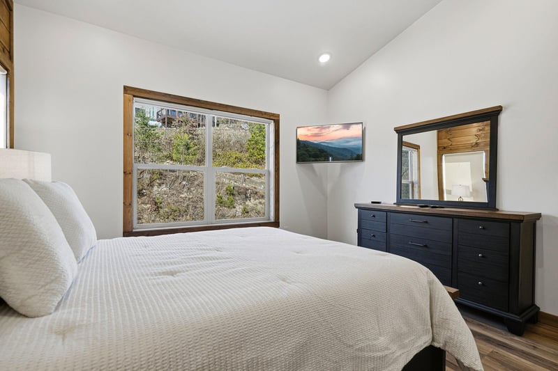 Your peaceful bedroom features mountain views, a wallmounted TV, and elegant furnishings for ultimate relaxation after exploring the area.