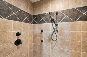 Rinse away your cares in this beautifully tiled walkin shower with dual fixtures and elegant bronzetoned hardware.