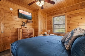 Cozy woodpaneled bedroom where youll drift off to mountain views on the TV while the ceiling fan keeps you comfortable.