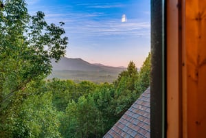 Mountains and forest stretch out before you in this peaceful view—perfect for sipping coffee while natures grandeur fills the horizon.