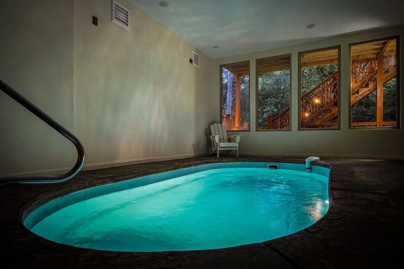 Slip into this glowing indoor pool, perfectly nestled beneath treehouse views. The serene space invites you to unwind as evening light filters through the windows, creating your own private oasis.