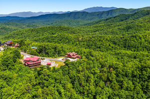 Nestled among lush forested mountains, the property offers a secluded escape with sweeping views of the surrounding natural landscape and distant peaks.
