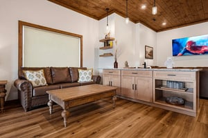 Sink into your private living space featuring warm wood accents and a cozy leather sofa—the perfect retreat after a day of exploring.