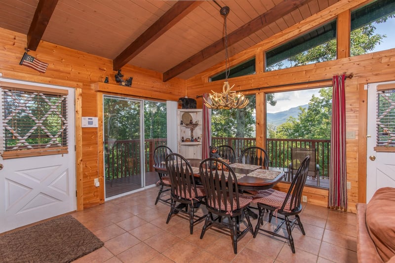 Dining space with seating for six and floortoceiling windows at Bushwood Lodge, a 3bedroom cabin rental located in Gatlinburg