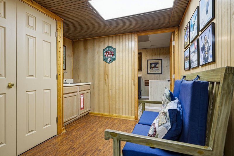 A welcoming entryway with warm wood paneling and a cozy bench sets the tone for your mountain getaway. The custom game room sign hints at the fun that awaits you inside.