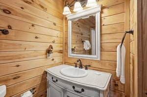 Rustic charm meets modern comfort in this cozy log cabin bathroom, where warm wood walls and vintage vanity create your perfect mountain retreat.