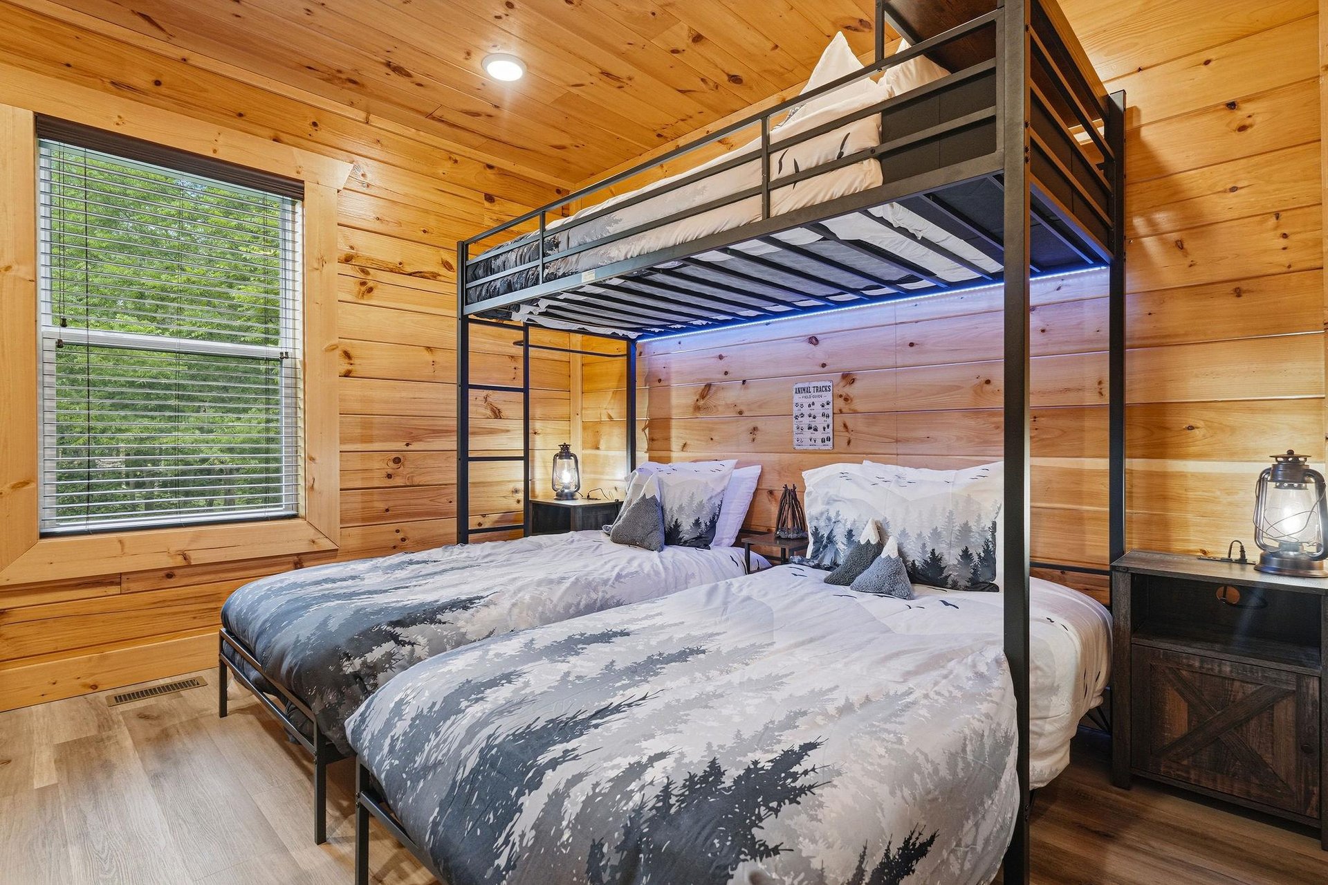 Your cozy retreat features rustic wood walls and bunk beds dressed in mountaininspired linens. Wake to peaceful forest views through your window and unwind by the charming lantern nightstands.