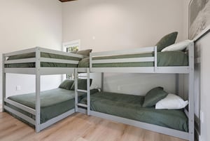 Perfect for the kids This cozy bunk room sleeps four with soft sage linens and natural light streaming in.