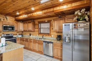 Your fully equipped kitchen features granite countertops, stainless steel appliances, and warm wood cabinetry—perfect for preparing memorable meals together.