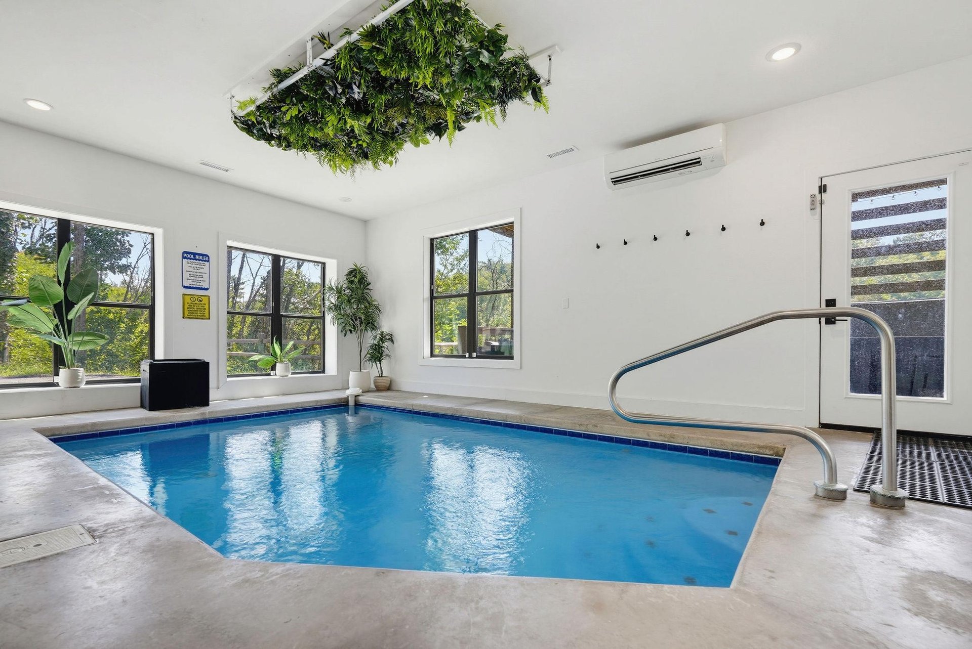 Slip into your own private indoor pool, where bright windows frame leafy views and a stylish hanging garden adds a fresh, tropical vibe overhead.