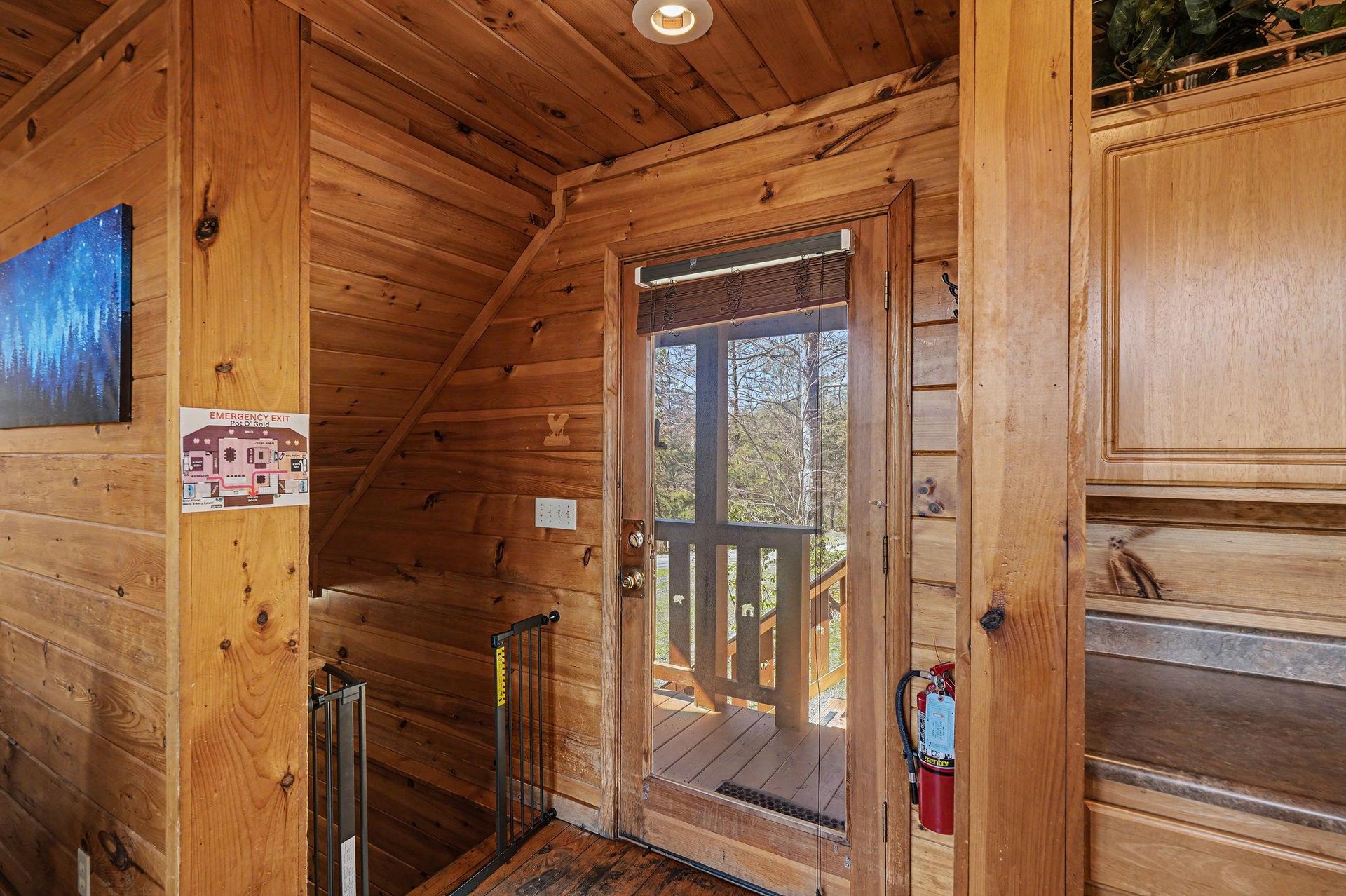 Step into your cozy cabins warm wooden entryway, where rustic charm meets comfort with natural light streaming through glass doors.