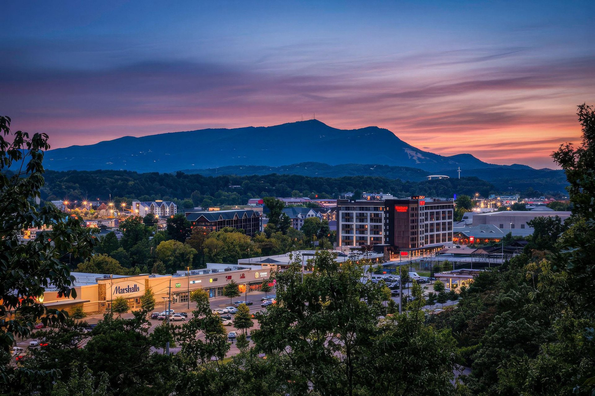 Stunning mountain backdrop and city lights frame the propertys scenic location, ideal for exploring the vibrant local area and natural beauty.