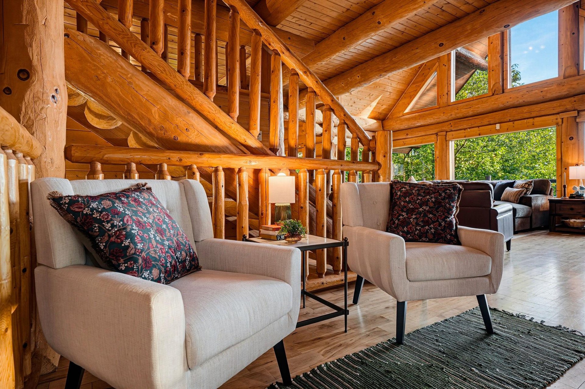 Sink into plush seating beneath soaring log beams and let natural light pour through expansive windows. Your peaceful retreat awaits in this beautifully crafted space.