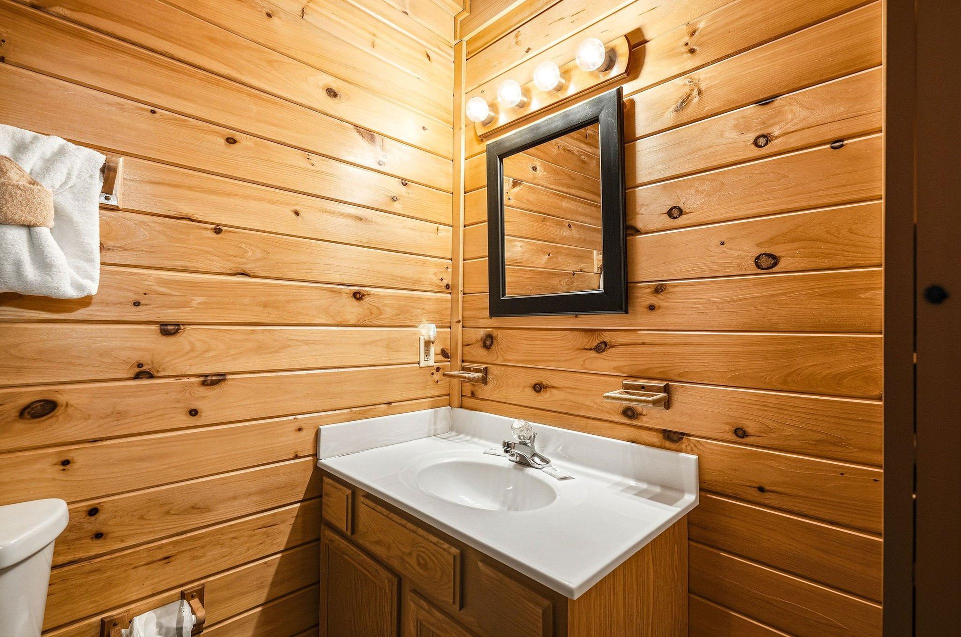 Warm woodpaneled bathroom with fresh towels ready for your arrival. Clean, cozy, and cabinperfect.