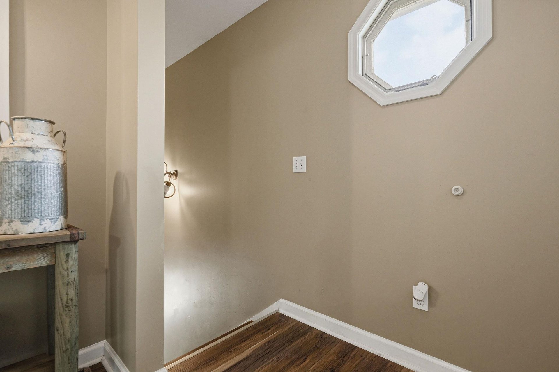 Natural light streams through the skylight above, illuminating this cozy nook with warm hardwood floors and a touch of rustic charm.