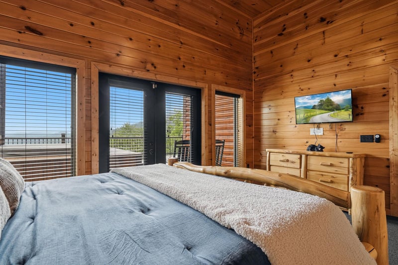 Wake up surrounded by warm wooden walls with French doors opening to your private balcony and mountain views on the TV—your serene escape awaits.