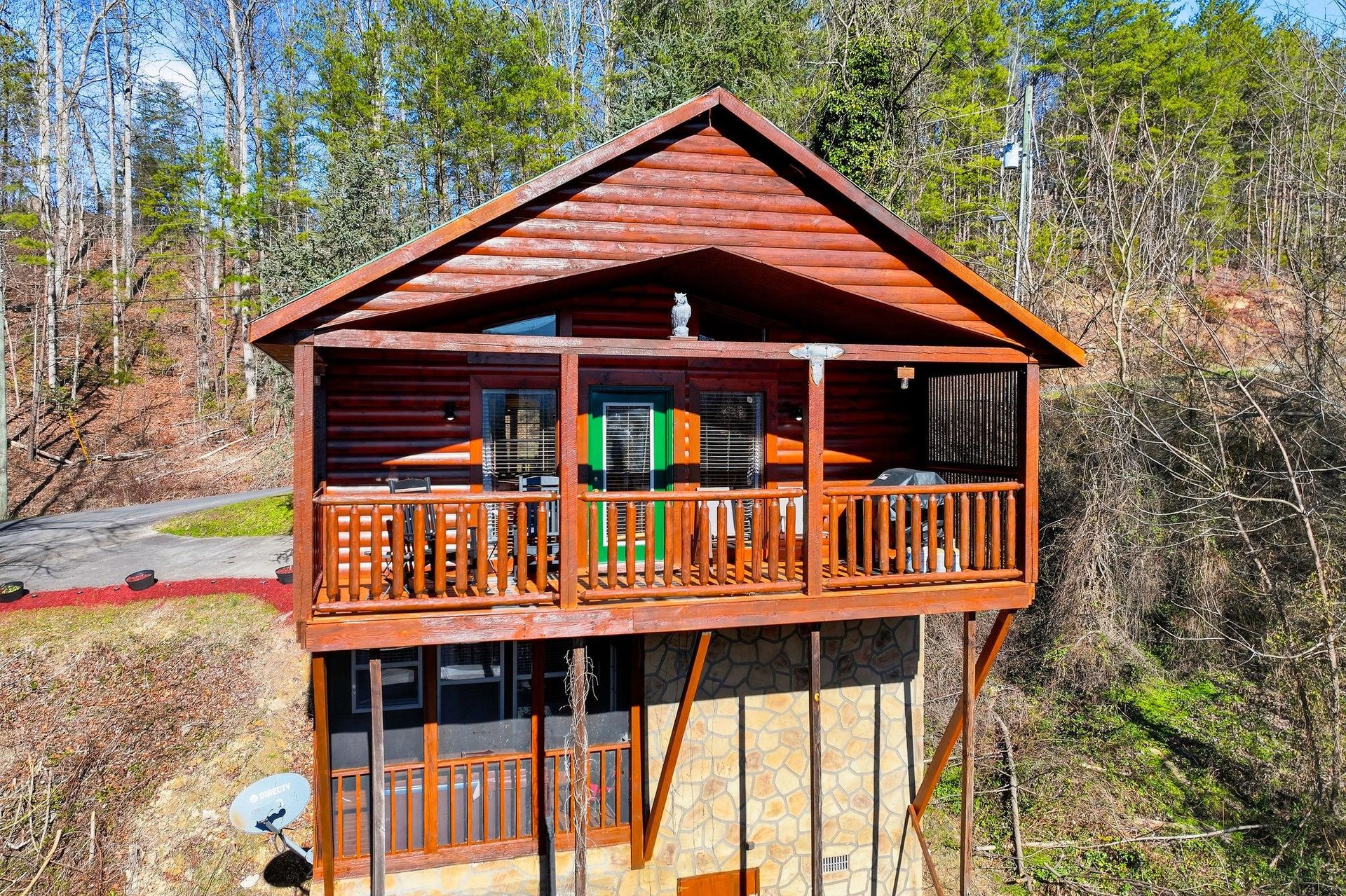 This charming log cabin nestled in the wooded hills offers a perfect retreat with its covered deck and natural stone foundation.