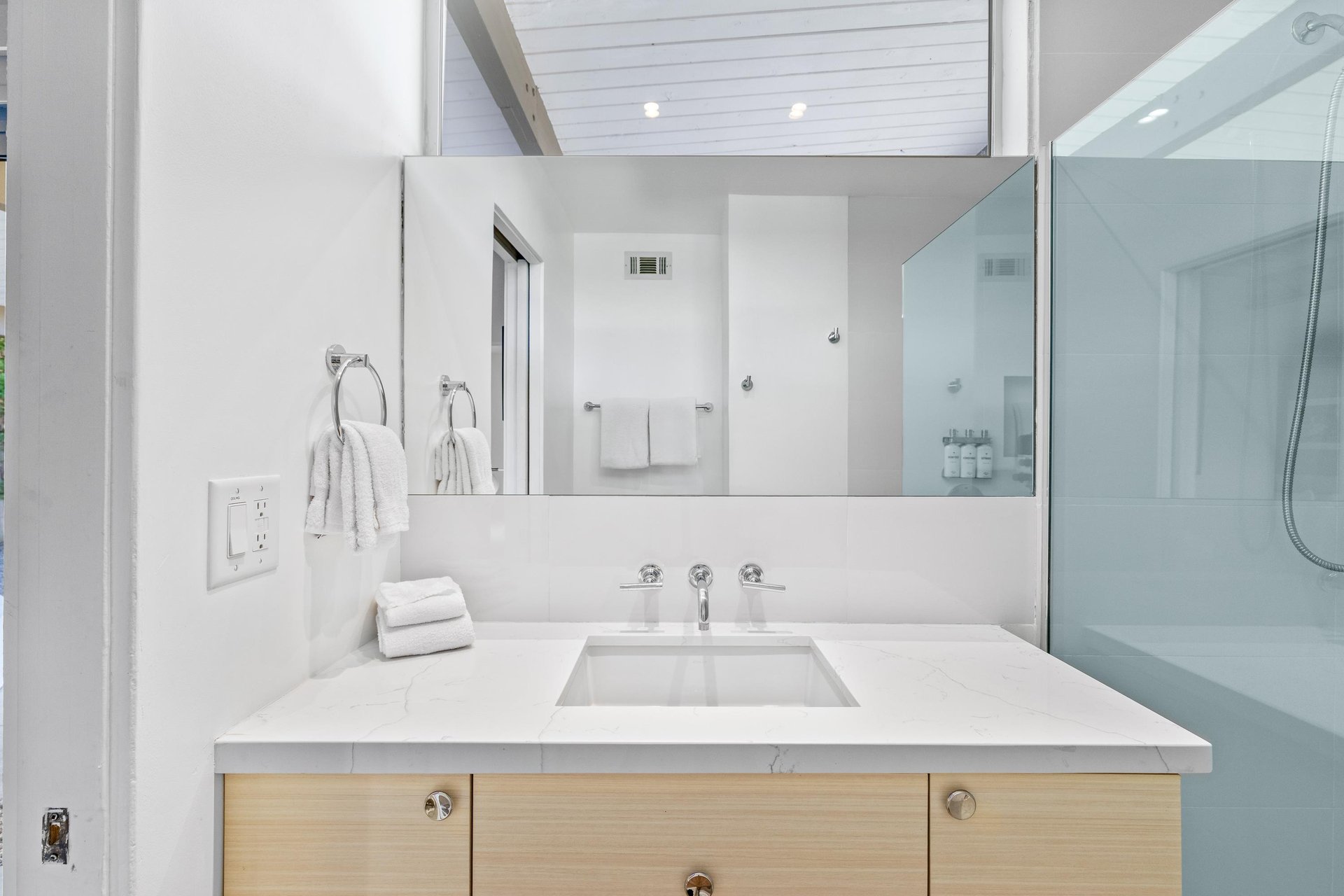 Unwind in your pristine ensuite with sleek marble counters, fresh linens, and a spacious glass shower waiting to refresh you.