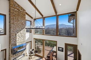 Gather around the stone fireplace and watch mountain views transform through floortoceiling windows in this soaring living space.