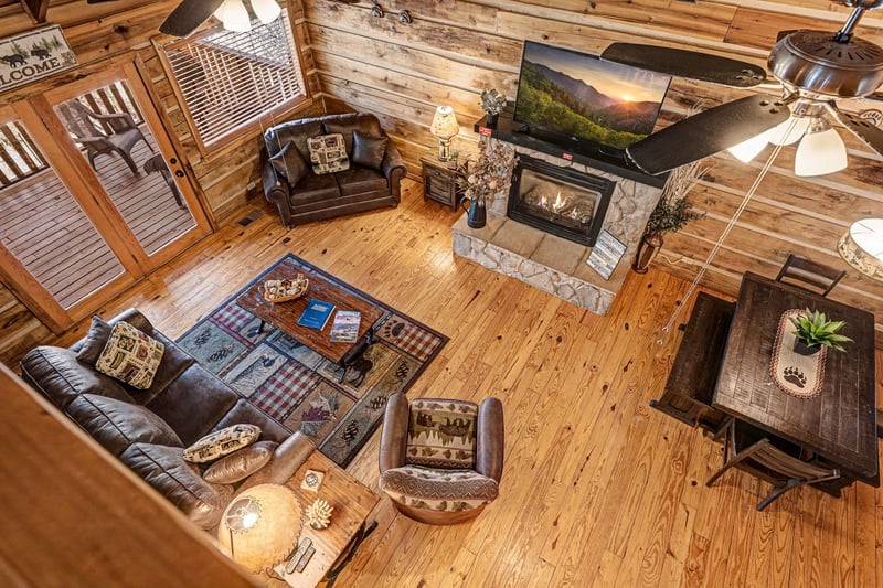 Relax in your cozy log cabin living room with leather seating, warm fireplace, and rustic charm perfect for mountain getaways.