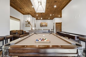 Challenge your friends to pool in this stunning game room featuring leather seating and modern design.