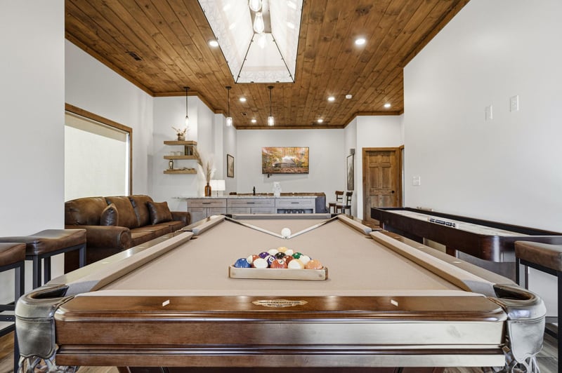 Challenge your friends to pool in this stunning game room featuring leather seating and modern design.
