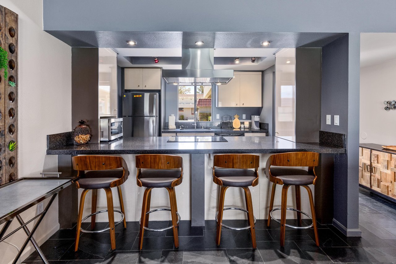Counter seating for 4 guests, stainless steel appliances, and cooking essentials.