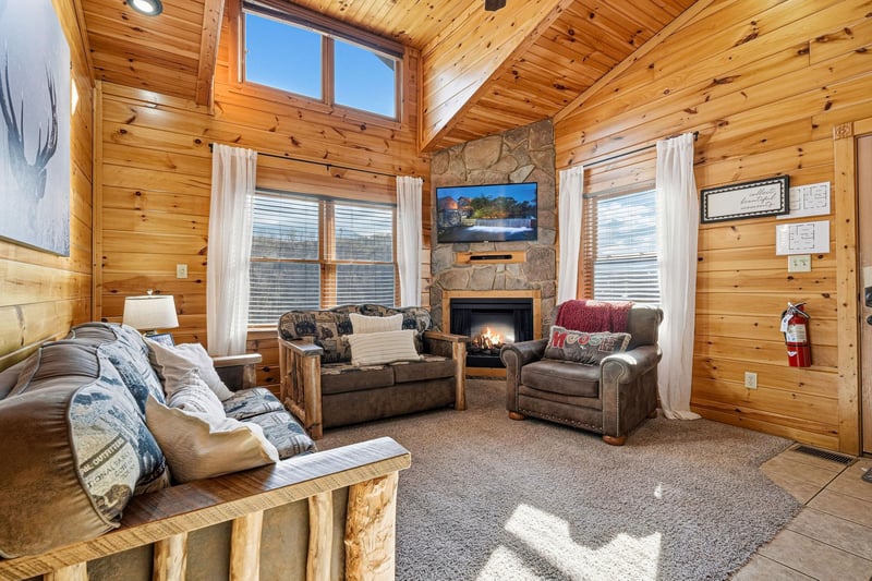 Sink into plush seating by your crackling stone fireplace, where rustic wood beams and mountain charm create the perfect cozy retreat.