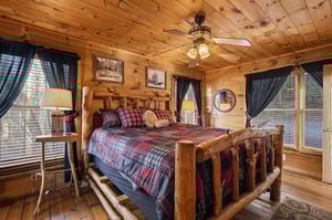 Your rustic log bedroom creates a cozy mountain retreat with handcrafted furnishings and warm plaid bedding.