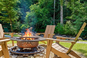 Picture yourself relaxing in this cozy Adirondack chair by the crackling fire pit, surrounded by lush forest and peaceful mountain air—your perfect outdoor retreat.