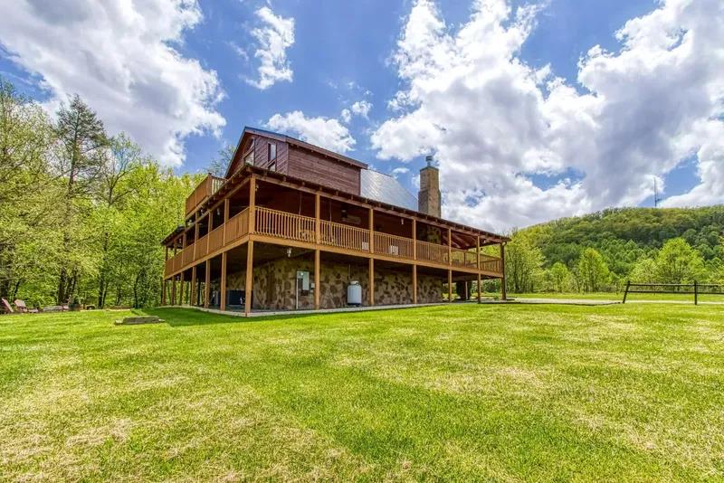 A rustic cabinstyle property set on expansive private grounds, surrounded by rolling hills and lush woodlands—an ideal countryside escape.