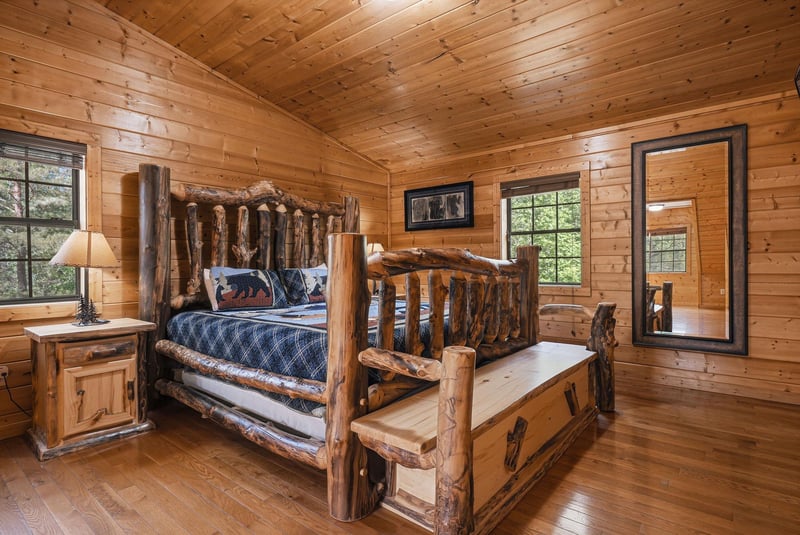 Drift off to sleep in this handcrafted log bed, surrounded by warm pine walls and peaceful forest views through your windows.