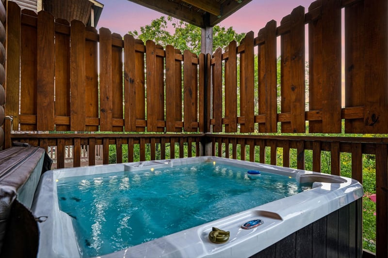 Soak away your stress in this private hot tub surrounded by wooden privacy fencing, perfect for evening relaxation under the sky.