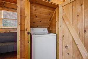 Your cozy cabin features convenient inunit laundry tucked beneath rustic wood stairs, making extended stays effortless.