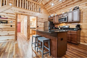 Your cabin kitchen combines rustic charm with modern convenience, featuring granite counters and a breakfast bar perfect for morning coffee.