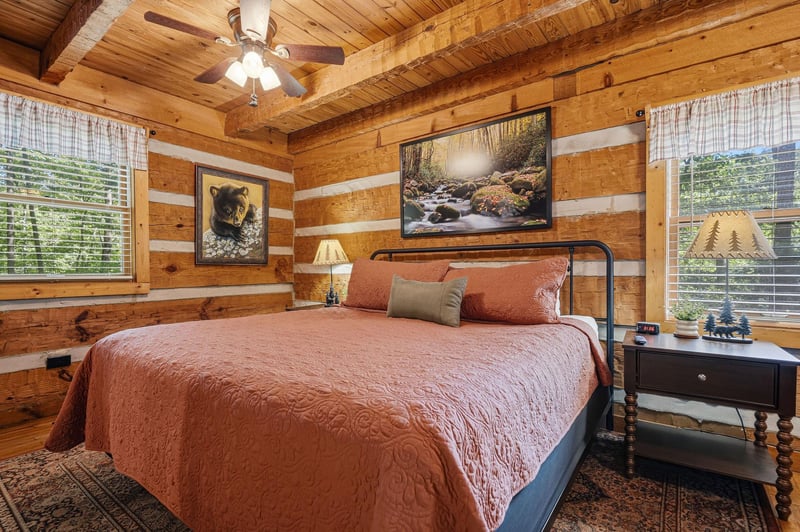 Warm wood walls and exposed beams create a cozy cabin retreat where youll drift off beneath natureinspired artwork and soft lighting. Your rusticchic escape awaits.