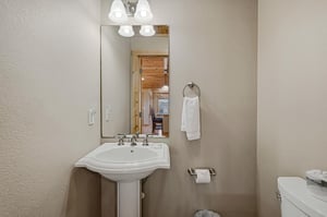 Your private powder room features a classic pedestal sink and warm lighting for comfortable daily routines.