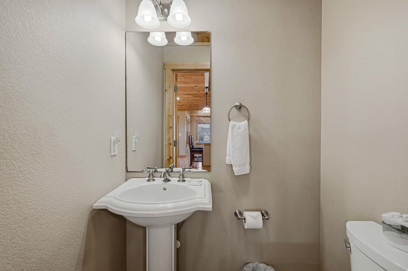 Your private powder room features a classic pedestal sink and warm lighting for comfortable daily routines.
