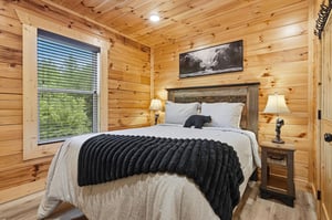 Drift off in your cozy bedroom, wrapped in rustic wood warmth and soft linens, with gentle light filtering through the window to greet your mornings.