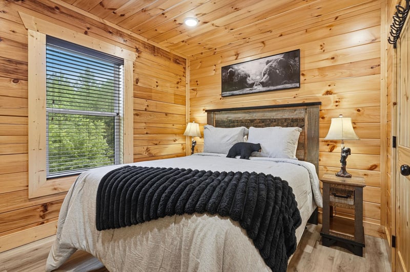 Drift off in your cozy bedroom, wrapped in rustic wood warmth and soft linens, with gentle light filtering through the window to greet your mornings.