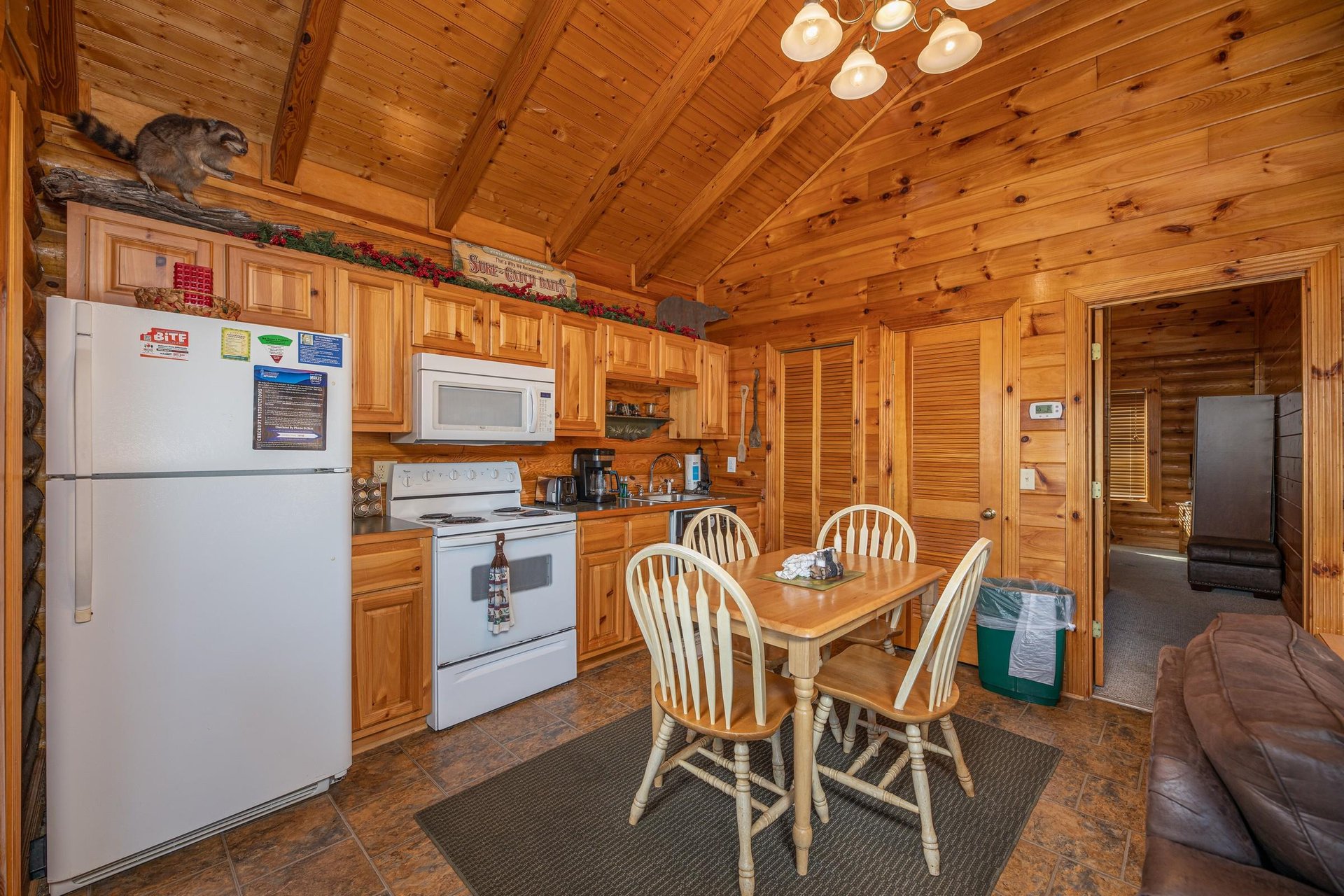 Kitchen with white appliances and dining space for 4 at Gone Fishin, a 2bedroom cabin rental located in Pigeon Forge