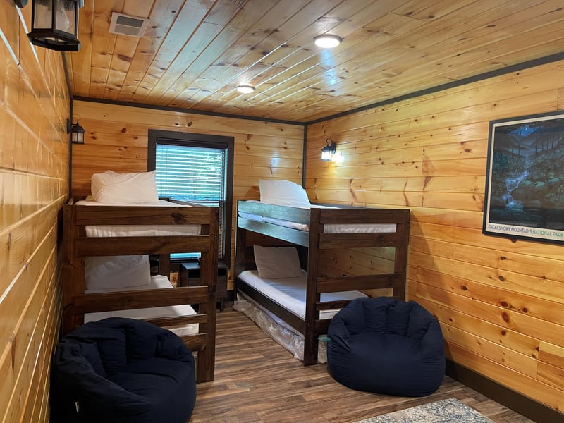 Unwind in your own cozy mountain bunk room with warm wood walls and fresh linens ready for restful nights.